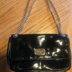 Michael Kors black patent leather bag with gold chain strap.
